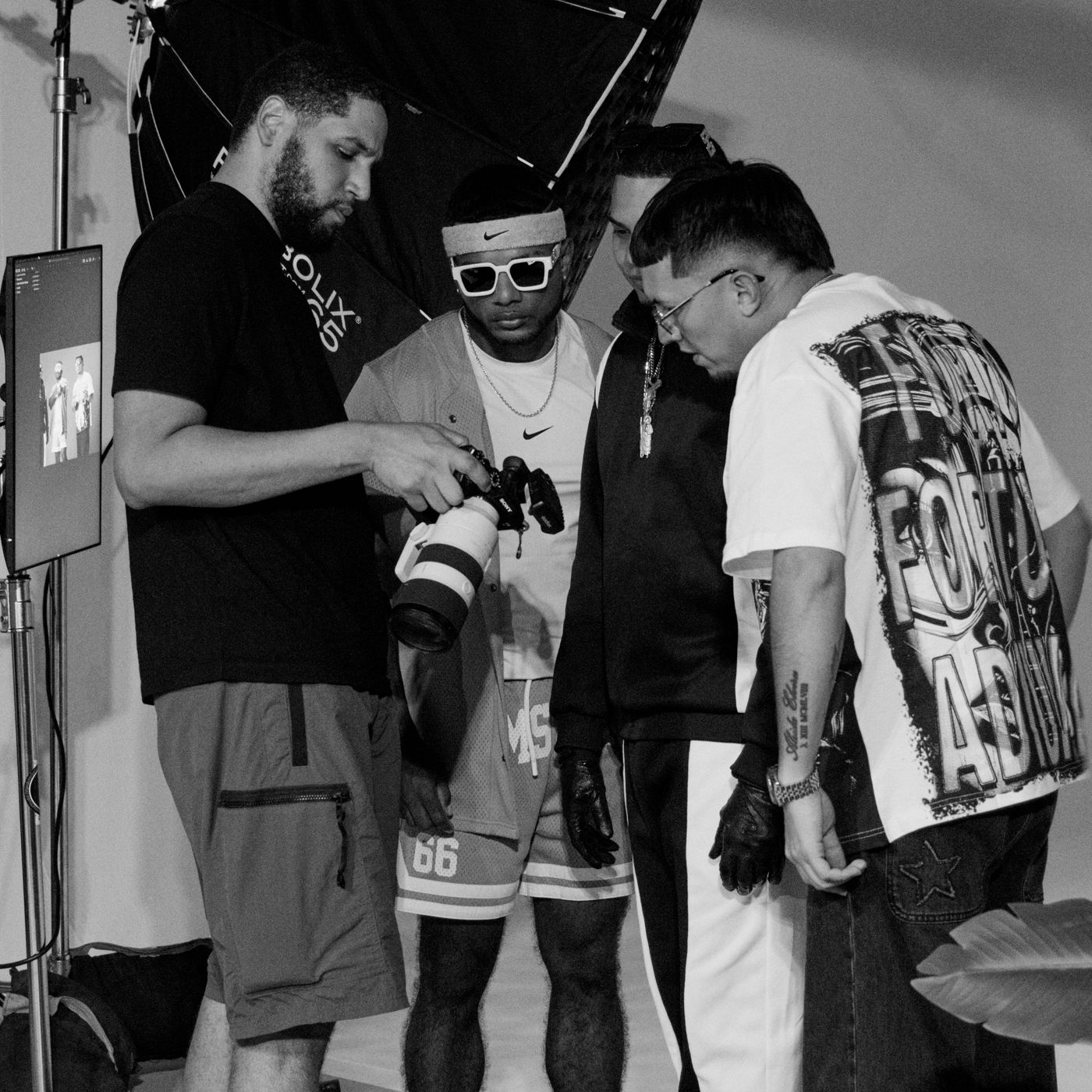 Black and white behind the scenes shot of Gerson and artists on set
