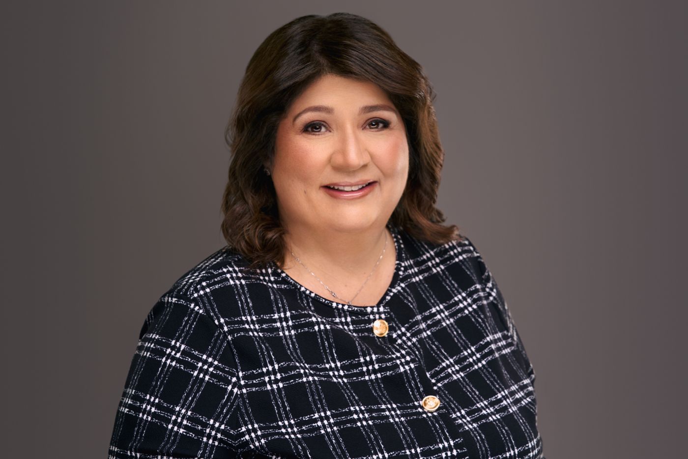 Smiling woman in a black and white tweed jacket