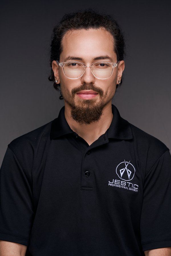 Barber in clear glasses and a black Jestic polo