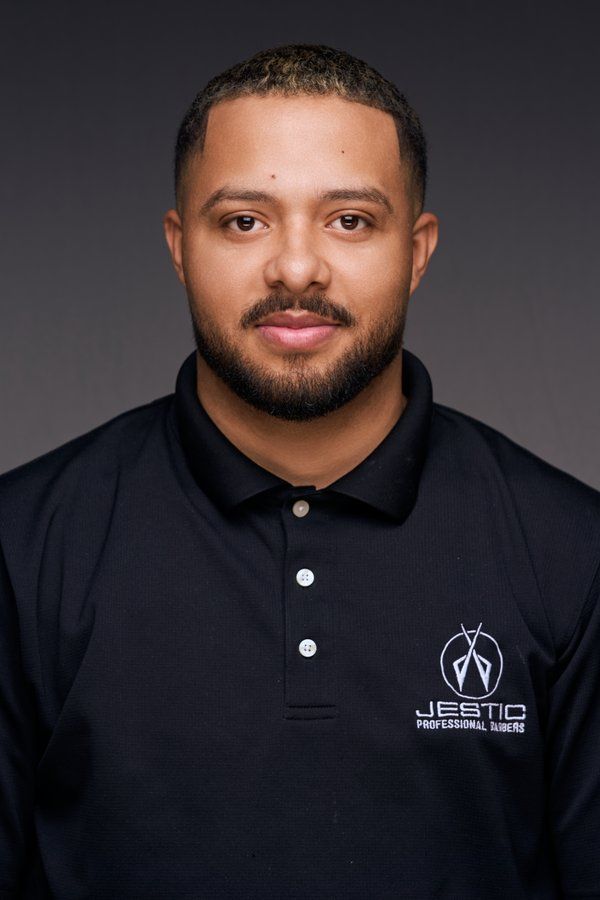 Barber in a black Jestic polo with a short beard